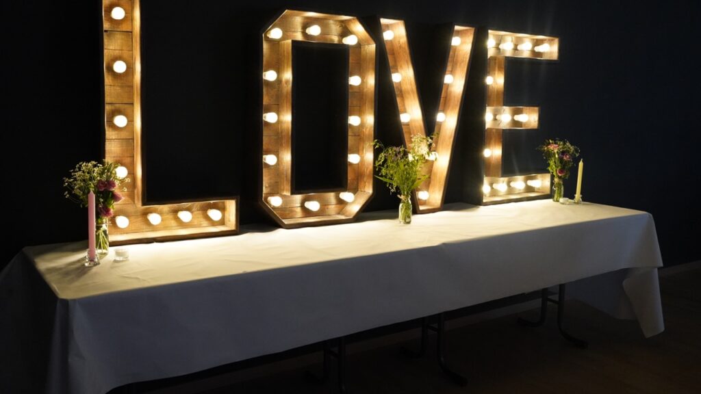 Ein Hochzeitstisch mit einem Holzschild mit der Aufschrift „Liebe“.